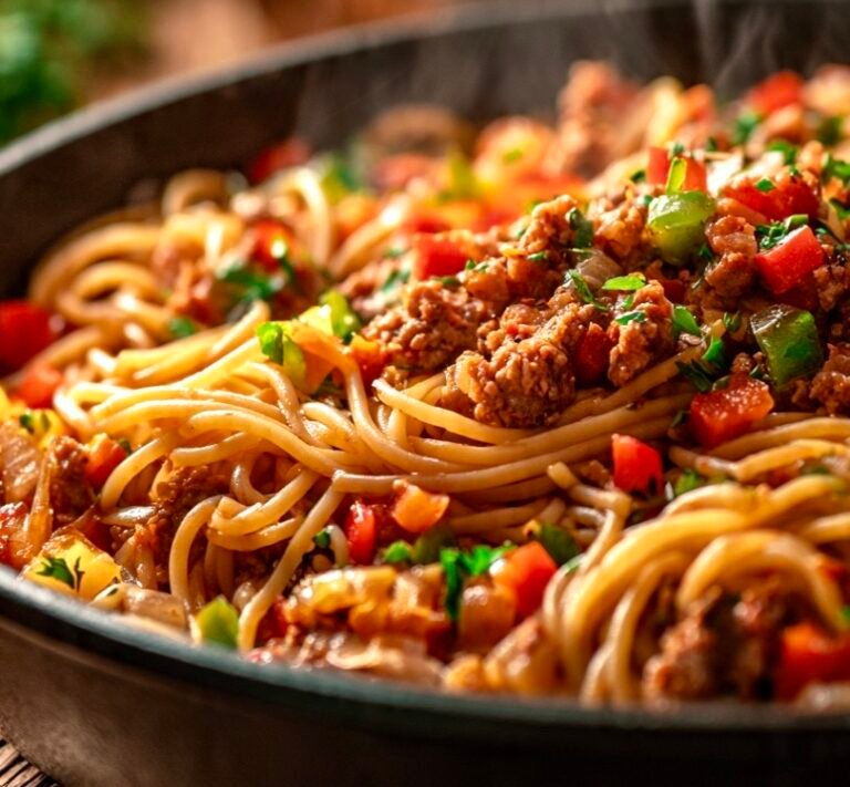 Dirty spaghetti in A large skillet containing cooked spaghetti noodles mixed with seasoned ground turkey, diced bell peppers, and onions in a savory Cajun sauce.