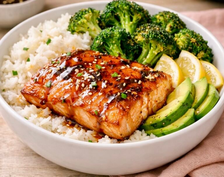 Air fryer salmon bowl with golden salmon, jasmine rice, roasted broccoli, avocado slices, and sesame‑soy drizzle in a bright, colorful dish.